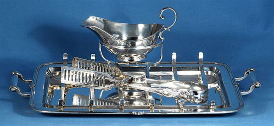 A 1930s silver asparagus draining dish with asparagus servers and sauce boat, by Goldsmiths & Silversmiths Co, tray length